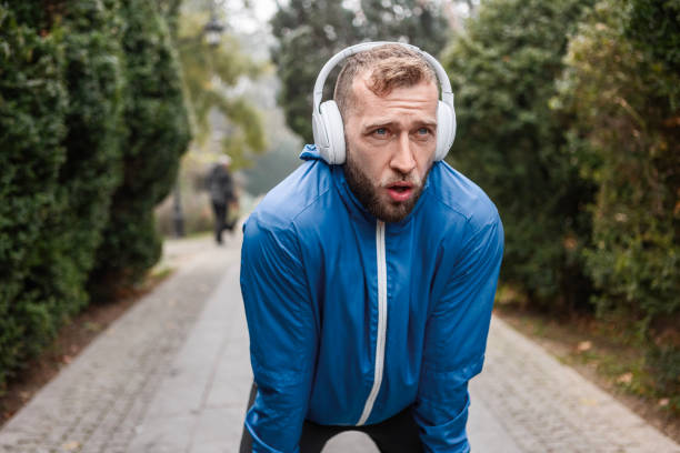 istock Jogger with Headphones Pausing in Foggy Park 2188393692
