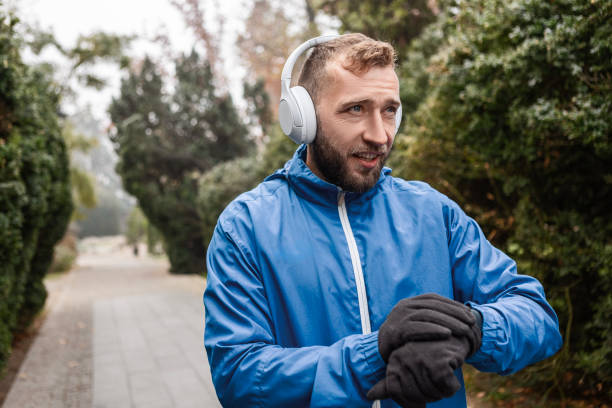 istock Runner Taking a Break During Morning Foggy Park Run Looking at Smart Watch 2188393884
