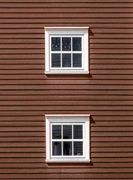 Two floors of windows on wooden facade. Demonstrating color of 2025 year