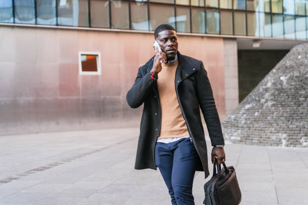 istock Businessman walking and talking on phone outside office 2188395976