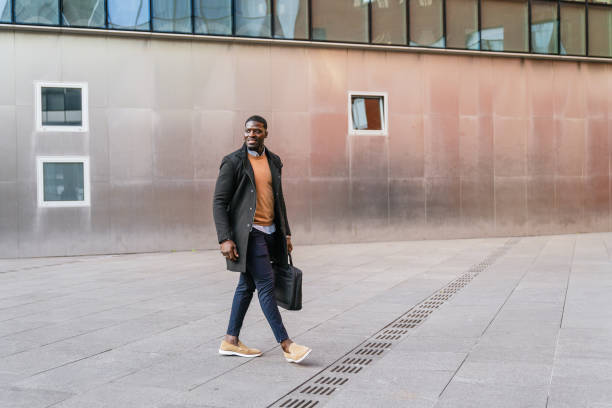 istock Businessman walking outside office building carrying briefcase 2188396025