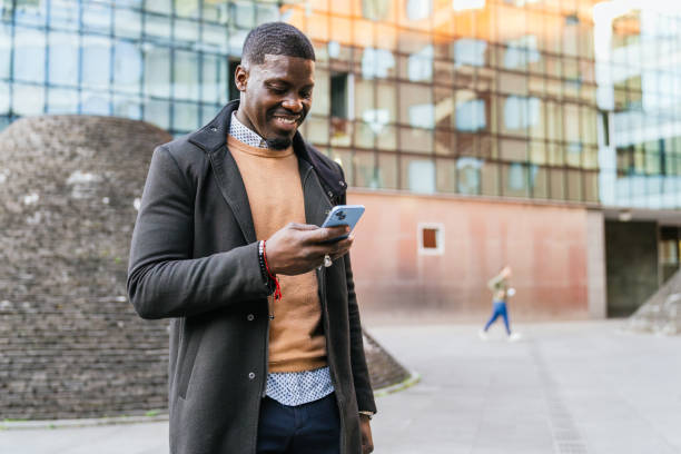 istock Smiling businessman using smartphone in urban setting 2188396050