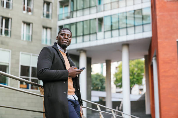 istock Businessman leaning on railing and using smartphone in urban setting 2188396093
