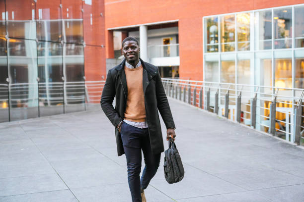 istock Young businessman walking outside a modern office building 2188396108