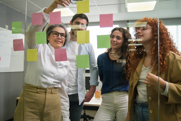istock Business team brainstorming using sticky notes on glass wall in office 2188397464