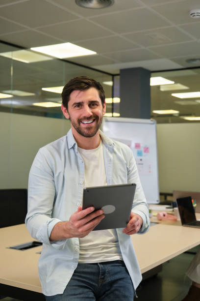 istock Smiling businessman holding digital tablet in modern office 2188397898