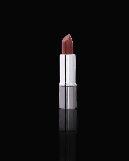 istock Nude lipstick with a silver casing displayed on a black reflective surface, showcasing an elegant and minimalistic design 2188402990