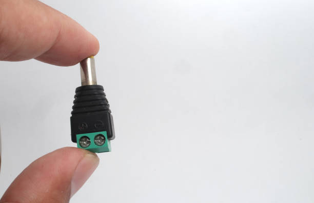istock A male DC jack with green screw connection held in hand on white background. 2188406213