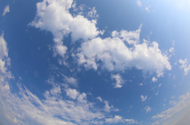 blue sky with white clouds and the sun filtering through a corner without any airplane trails ideal as a natural background and concept of pure air