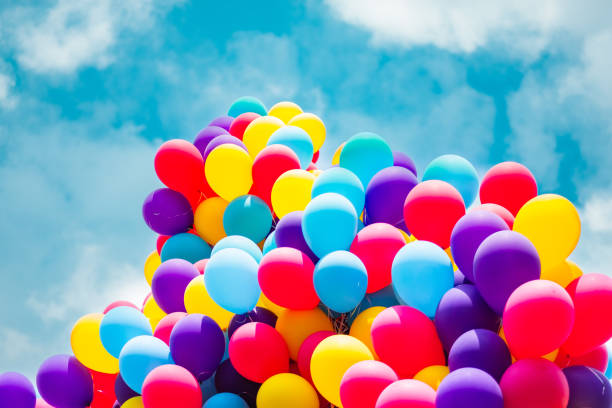 istock Vibrant Cluster of Multicolored Balloons Floating Against a Sunny Blue Sky, Symbolizing Joy and Celebration in a Festive or Party Environment, Capturing the Essence of Happiness and Freedom 2188408446