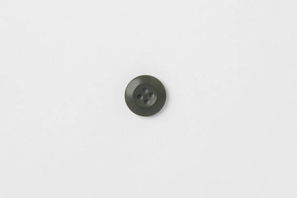 istock A green small round button with four holes is isolated in white background. 2188409584