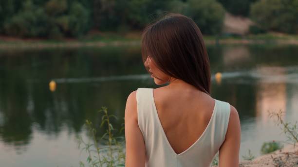 istock Young woman admiring a lake view on a summer evening 2188410704