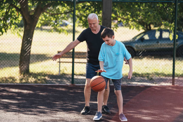 istock Youth being guided by elder in basketball practice 2188412236