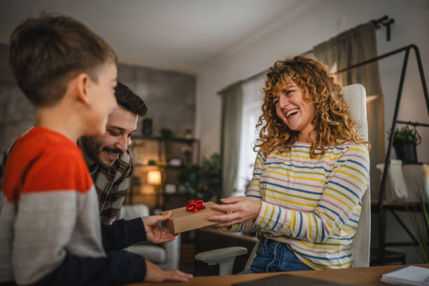 istock Dad and son surprise mum with gift while she work from home 2188413505