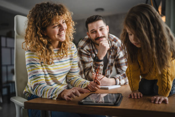 istock mum, dad and daughter use digital tablet on wooden table 2188414792