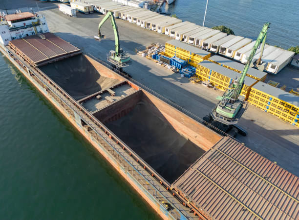 istock Loading operations with a portal crane in a warehouse in the port.Grain transshipment from cargo ship to truck holds 2188415888