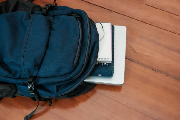 istock Blue backpack with books and laptop for student or working on the wooden table 2188416890