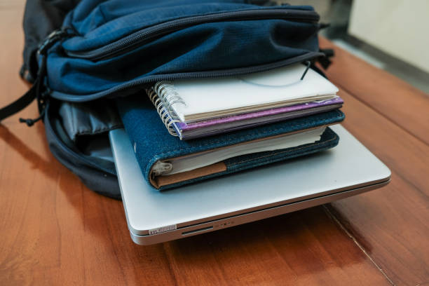 istock Blue backpack with books and laptop for student or working on the wooden table 2188416911