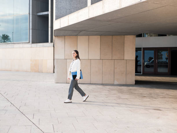 istock Young professional walking outside a modern office building with confidence 2188417854