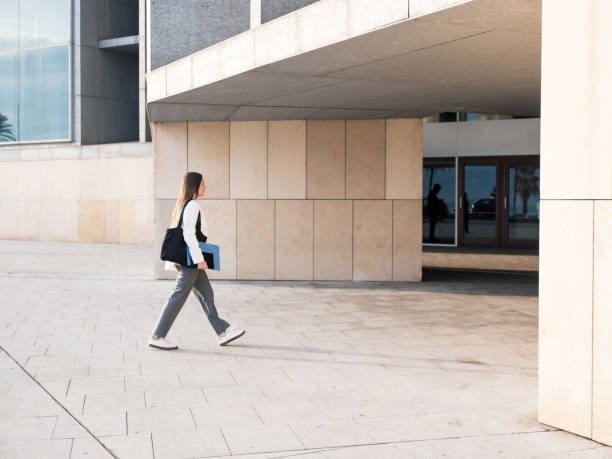 istock Young professional woman walking into a modern office building 2188417877