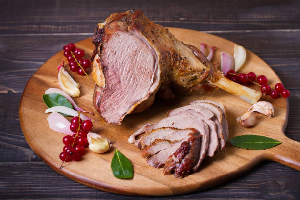 istock Roasted leg of lamb on serving board with potatoes and broccoli 2188424552
