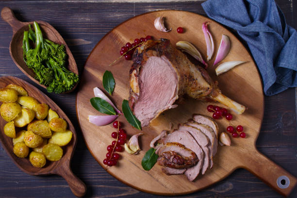 istock Roasted leg of lamb on serving board with potatoes and broccoli 2188424599