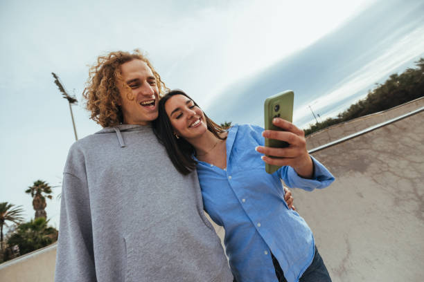 istock Young couple taking a selfie while having fun outdoors 2188427493