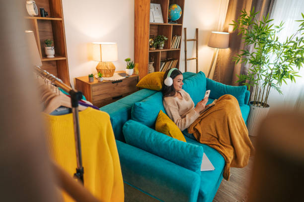 istock Woman looking at social media on her cell phone while sitting on the sofa 2188429489