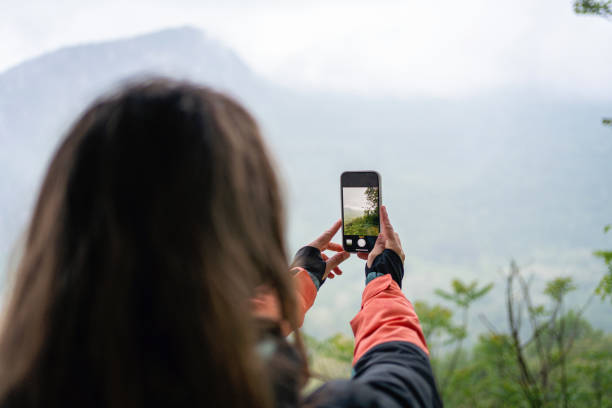 istock Young woman taking photos while enjoying hiking on a cloudy day 2188429552