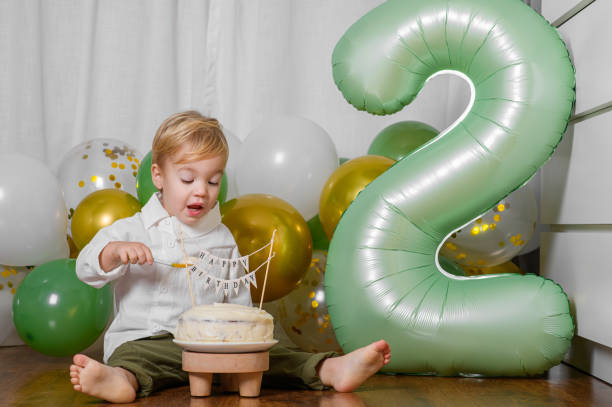 istock Toddler Celebrating Second Birthday with Cake and Balloons 2188429925