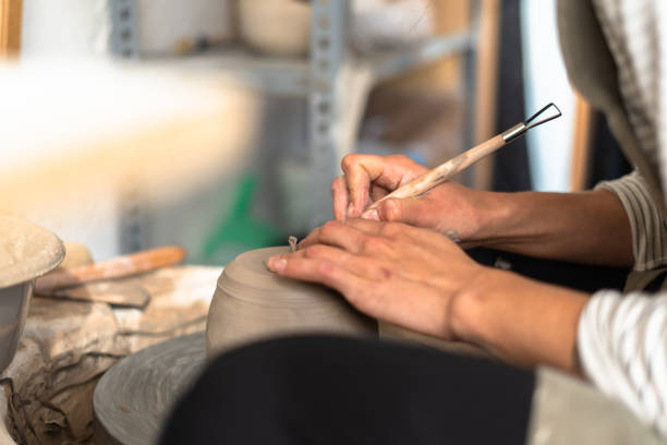 istock Young entrepreneur ceramist carefully shaping clay pot in workshop 2188433646