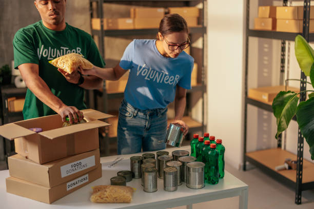 istock Volunteers packing food donations in boxes 2188437785