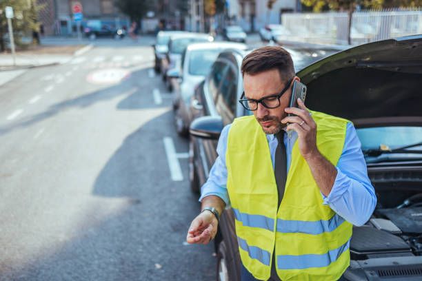 istock Man in Safety Vest Calling for Roadside Assistance 2188441946