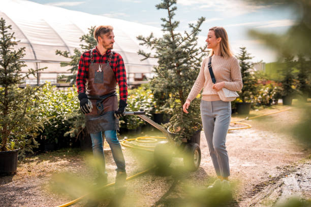 istock Caucasian Gardener Assists Female Customer with Potted Tree 2188443152