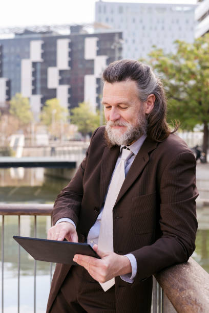 istock middle age male in formal outfit browsing tablet 2188452398