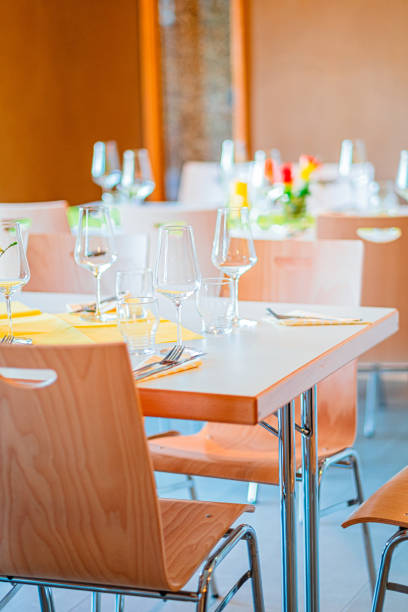 istock Restaurant Table Setting with Wine Glasses and Yellow Napkins in a Modern Dining Environment Creating a Sophisticated and Inviting Atmosphere for Gourmet Dining Experiences and Special Occasions 2188452473