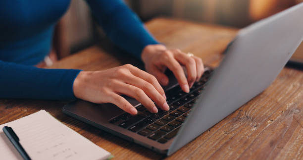 istock Hands, typing and laptop on desk, research and writer with notebook for ideas, creative and self publishing. Table, entrepreneur and planning for novel, literature and person in home office and Japan 2188452587