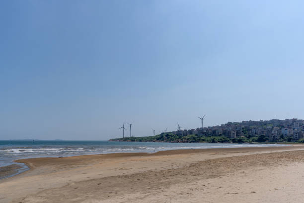 Wind Turbines On Beach Against Clear Blue Sky