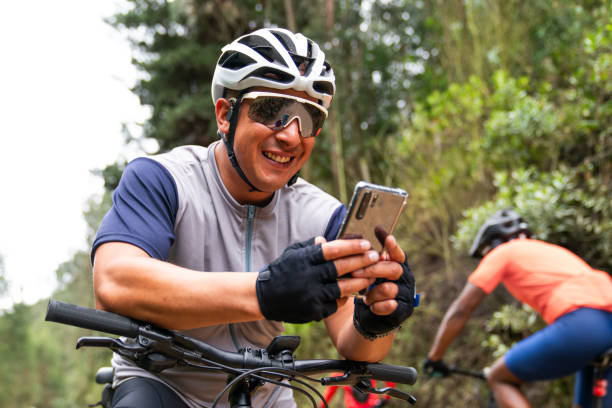 istock Happy cyclist mountain biking and using his cell phone 2188455581