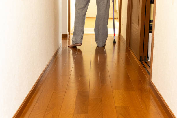 A person walking down a corridor with a cane
