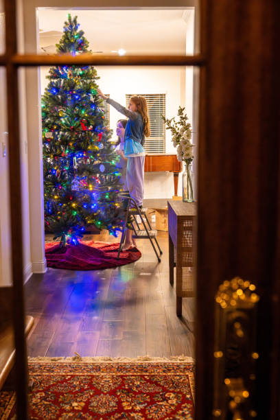 istock Children Decorating the Christmas Tree throug the Window 2188458225