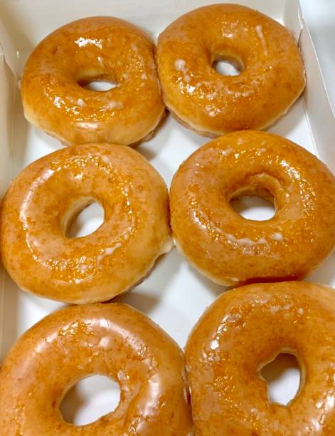 istock A classic glazed donut with a soft, fluffy texture and a sweet, glossy coating. Perfectly balanced between light and sugary, making it an irresistible treat for any time of the day. 2188461331