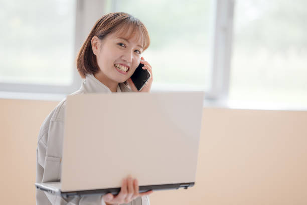 Cropped shot of an attractive young woman businesswoman making a phone call while working on her laptop at home.