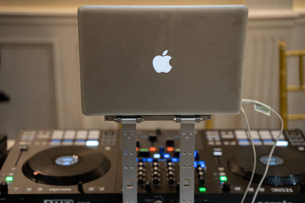 Fragment of a black laptop and white headphones, Personal modern multimedia concept. Black background, top view