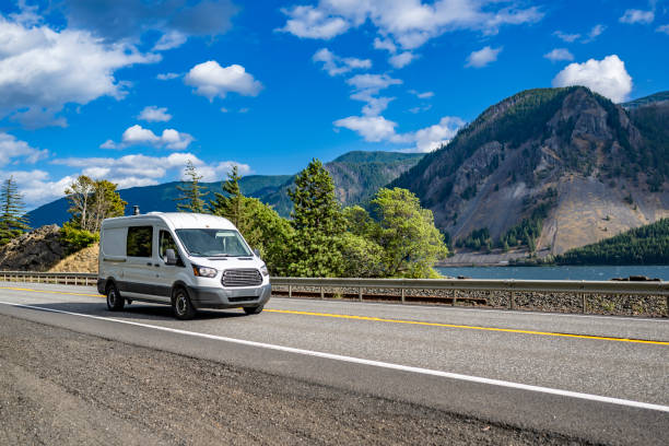 Cargo white mini van for small business and deliveries running on the road along the Columbia river stock photo