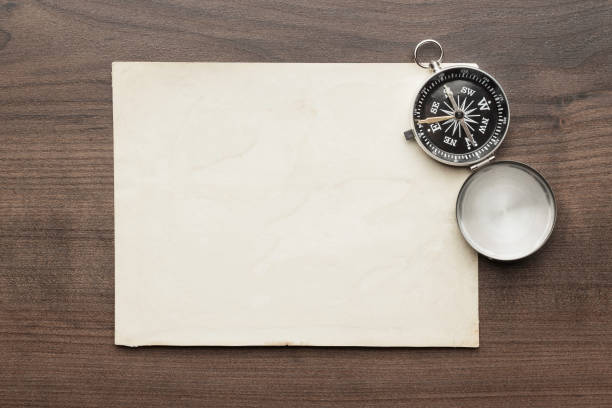 istock Compass and old paper on the brown wooden table 2188479471