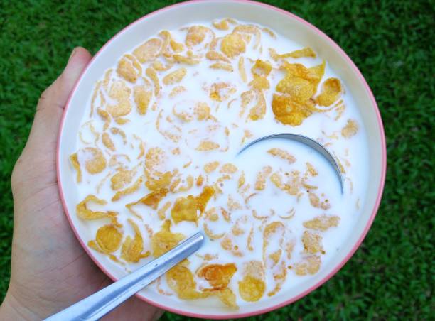 Hand holding A bowl of Cereal and milk.