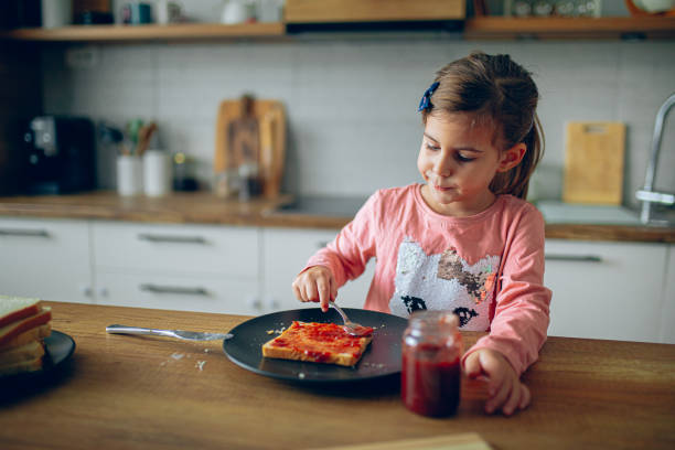 istock Happy girl making sandwiches in the kitchen 2188484623