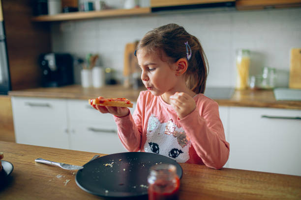 istock Little girl is having breakfast in the kitchen 2188484656