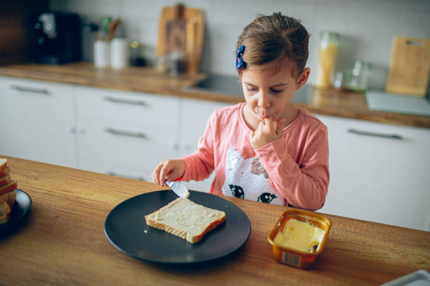istock Happy girl making sandwiches in the kitchen 2188484831